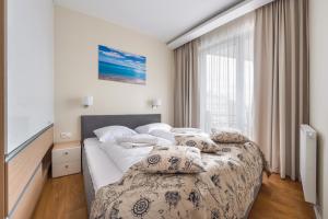 a bedroom with two beds and a window at Apartamenty Sun & Snow Marina Kąty Rybackie in Kąty Rybackie