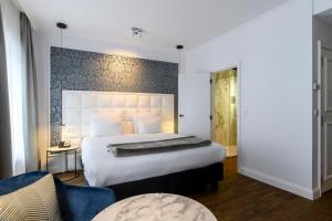 a hotel room with a bed and a dresser at Hotel Rubens-Grote Markt in Antwerp