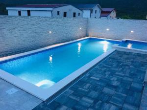 a large swimming pool with blue water at night at VILLA ŠUŠANJ 2 in Cesarica