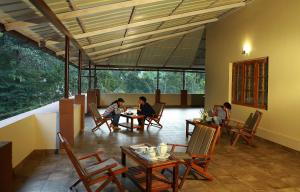 a group of people sitting at a table in a room at Dakshin Ghats in Tariyod