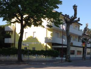 a building with two trees in front of it at Pensione Imperia in Lignano Sabbiadoro