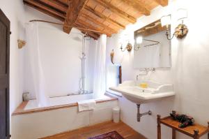 a bathroom with a sink and a tub and a mirror at Castello Di Potentino in Seggiano