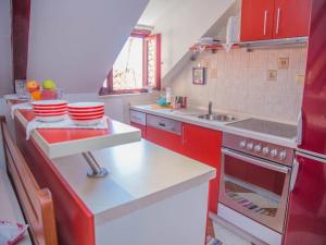 a small kitchen with red cabinets and a sink at Old town apartmant in Dubrovnik