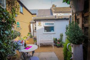 a small backyard with a table and chairs and a house at Oh So Snug in Whalley