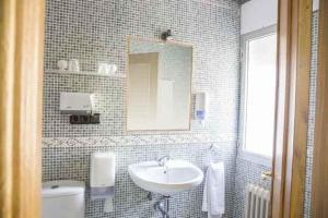 ein Badezimmer mit Waschbecken, Toilette und Spiegel in der Unterkunft Café Bar Hotel Jefi in Jaraiz de la Vera