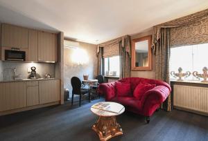 - un salon avec un canapé rouge et une table dans l'établissement Residentie De Laurier, à Knokke-Heist