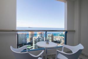 a table and chairs in a room with a large window at Hotel Madeira Centro in Benidorm