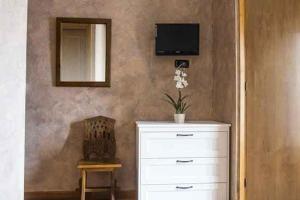 a room with a dresser and a mirror and a chair at Café Bar Hotel Jefi in Jaraiz de la Vera
