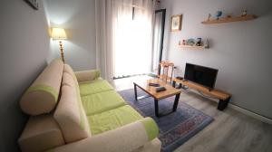 Una sala de estar con un sofá y un televisor. en Bujtina Shqiptare, en Tirana