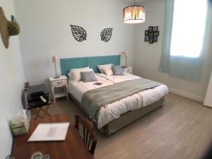 1 dormitorio con cama, mesa y sidx sidx sidx de mesa en Domaine de Ludeye en Listrac-Médoc