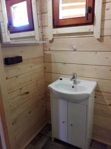 łazienka z białą umywalką i 2 oknami w obiekcie Gościniec Echo w mieście Piecki