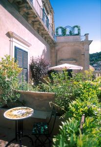 an outdoor patio with a table and an umbrella at L'Orangerie in Modica