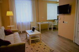 - un salon avec un canapé et une table avec un ordinateur portable dans l'établissement Central comfortable one-bedroom apartment, à Chişinău