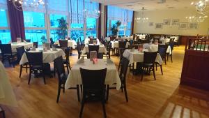 a restaurant with white tables and chairs and windows at WAGNERS Sporthotel Oberhof in Oberhof