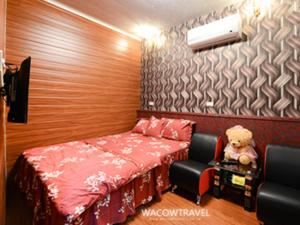 Habitación pequeña con cama y osito de peluche en Full House B&B, en Xiaoliuqiu