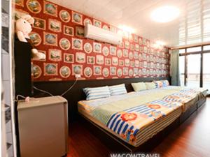 a bedroom with a bed and a wall with pictures at Full House B&B in Xiaoliuqiu