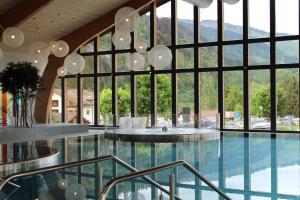 a large building with a pool and a large window at Hapimag Ferienwohnungen Andeer in Clugin