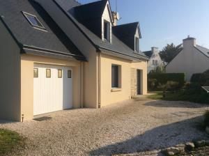 a garage with white doors on a house at Maison près de la Grande Plage in Bénodet