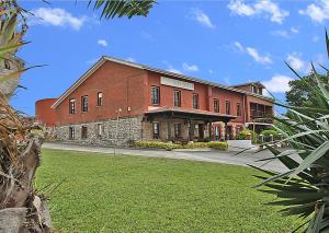 a large red brick building with a green yard at Posada la Hijuela in Queveda