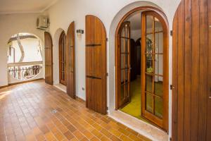 corridoio con porte in legno e pavimento piastrellato di Villa Arketa a Lignano Sabbiadoro