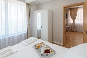 a hotel room with a tray of food on a bed at Mary Homes in Nesebar