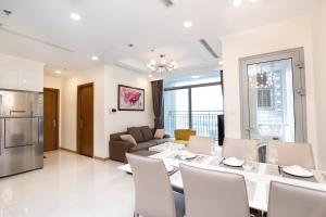 uma sala de jantar e sala de estar com mesa e cadeiras em Vinhomes Premium Apartment em Ho Chi Minh