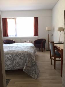 1 dormitorio con 1 cama, mesa y sillas en Hotel Laasby Kro, en Låsby