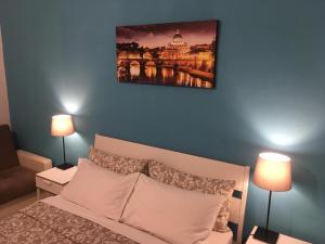 una camera con un letto bianco e 2 lampade di amoRaRoma, economy guest house with shared bathrooms a Roma