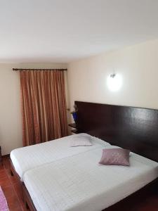 a bedroom with a large white bed with a wooden headboard at Casa Dos Gaios in Vieira do Minho +66 photos