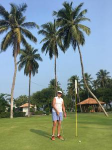 mężczyzna stojący na polu golfowym z palmami w obiekcie Amawin Resort w mieście Hambantota