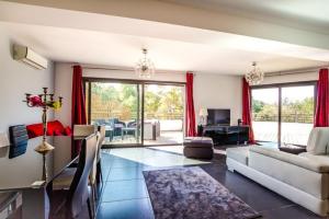 - un salon avec des rideaux rouges et un canapé dans l'établissement APPARTEMENT TERRASSE CITA DI SALI PORTO VECCHIO, à Porto-Vecchio