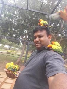 a man with parrots on his shoulders at Amawin Resort in Hambantota