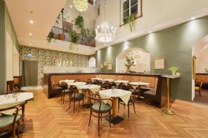 a restaurant with tables and chairs and a bar at Palais Hotel Erzherzog Johann in Graz