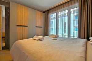 a bedroom with a large bed with two towels on it at Apartments Riva-Interauto in Umag