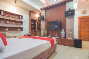 a bedroom with a bed and a flat screen tv at RedDoorz Syariah near Margahayu Raya in Bandung