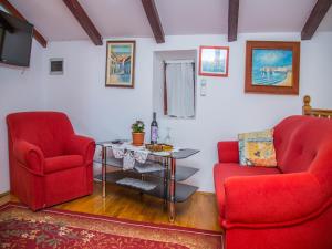 a living room with two red chairs and a table at Old town apartmant in Dubrovnik
