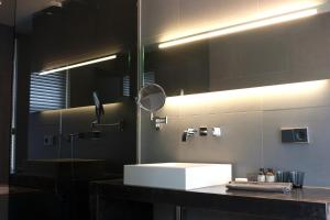 La salle de bains est pourvue d'un lavabo blanc et d'un miroir. dans l'établissement COMMUNE suites, à Amsterdam