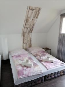 a bedroom with a bed with two towels on it at My Home Cibuka Apartman! in Hajdúszoboszló