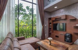 a living room with a couch and a television at The Country Villa in Ao Nang Beach