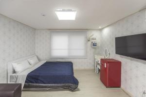 a bedroom with a bed and a flat screen tv at Big O Show Guesthouse in Yeosu