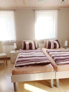 2 Betten in einem Zimmer mit 2 Fenstern in der Unterkunft Ferienwohnung Angelika Gries in Margetshöchheim