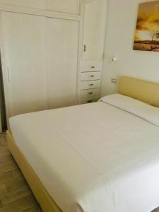 a bedroom with a white bed and a painting on the wall at Residence Le Terrazze in La Maddalena +13 photos