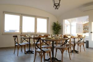 a dining room with tables and chairs and windows at B&B Cloud in Santa Maria Capua Vetere