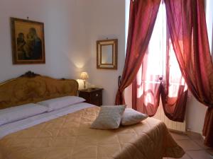 a bedroom with a bed with red drapes at Valverde Guest House in Tarquinia
