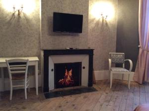 a living room with a fireplace with a tv above it at CHATEAU DE CHAVANNES in Tresnay
