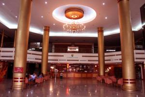 un vestíbulo de un hotel con columnas y una lámpara de araña en JP Emerald Hotel, en Yasothon