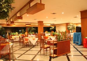 a restaurant with tables and chairs in a room at JP Emerald Hotel in Yasothon