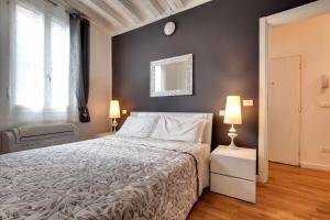 a bedroom with a large bed and two lamps at Charming Castello Apartments in Venice