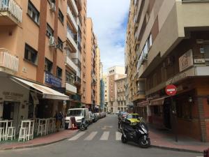 a city street with parked motorcycles and buildings at Apartments soho, Malaga center in Málaga