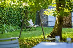 a couple of chairs sitting next to a tree at Hôtel de la Villeon in Tournon-sur-Rhône